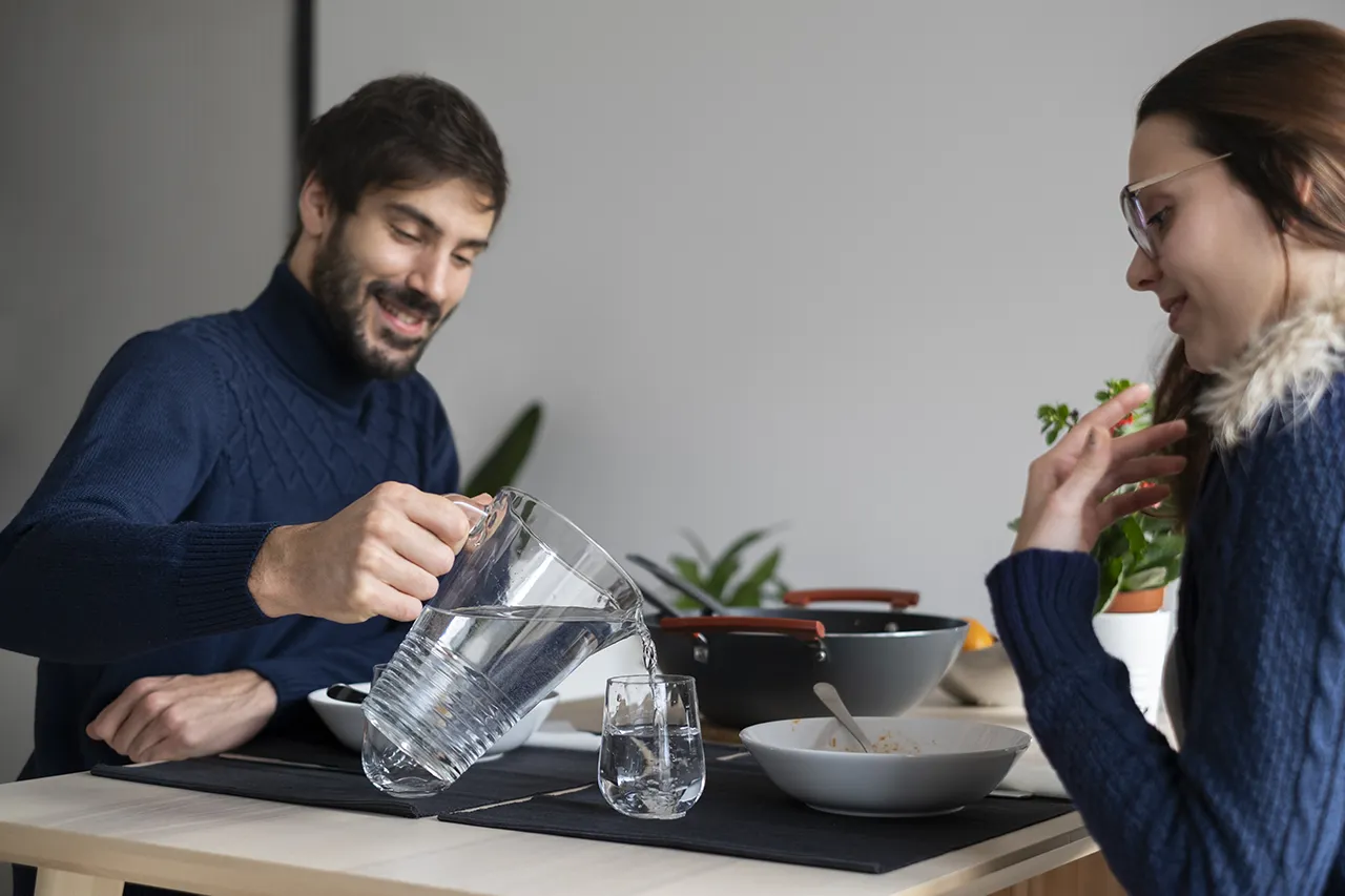 coppia di ragazzi bevono acqua purificata durante un pranzo